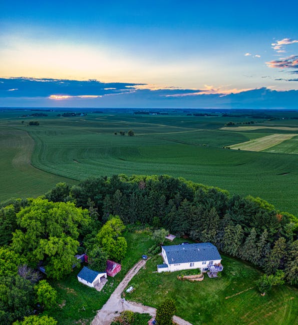 Stunning aerial view of a countryside estate surrounded by lush farmland in Minnesota at sunset.